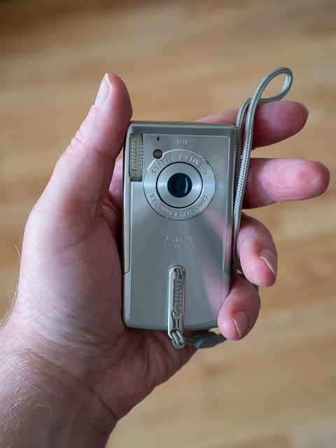 Canon IXUS i in hand to show scal.